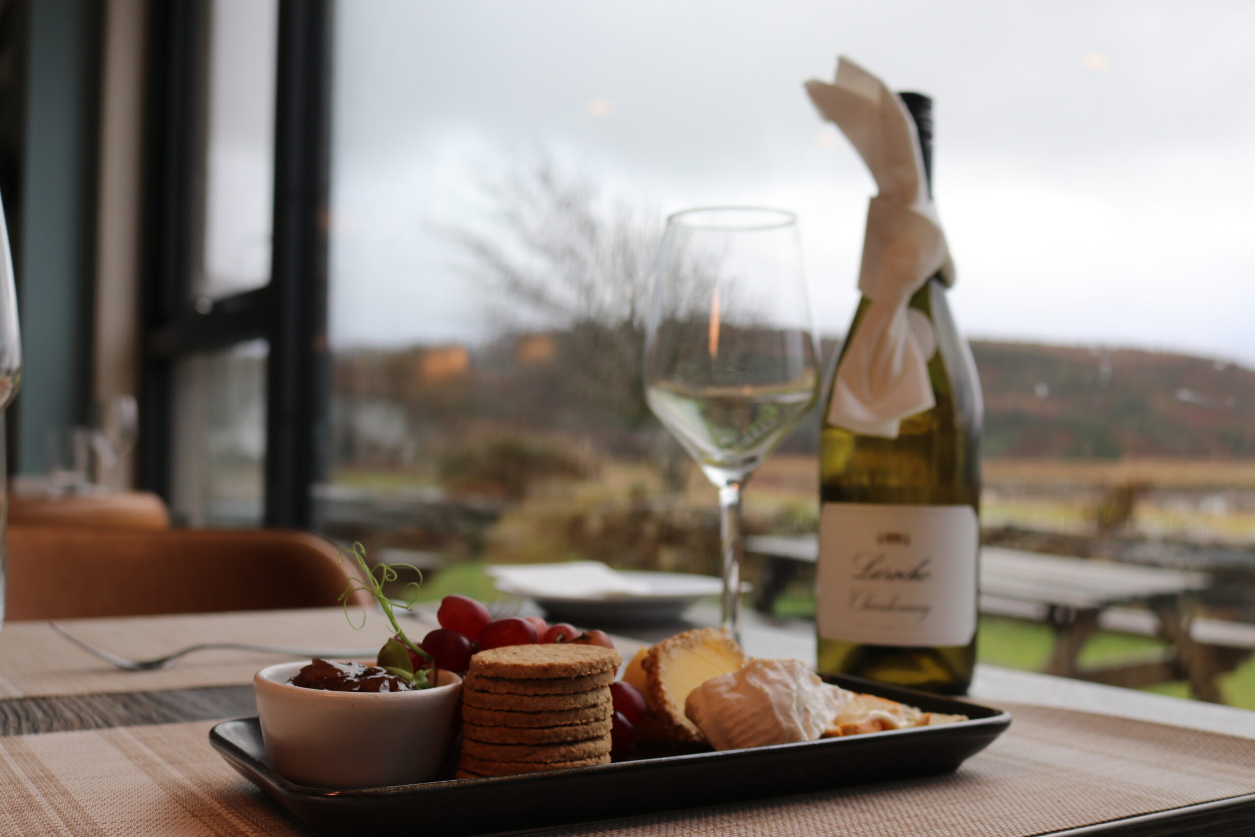 Cosy dining with wine and cheese at Balmacara hotel overlooking scenic countryside.