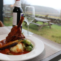 Cosy dining at Balmacara hotel with scenic countryside view; lamb shank with vegetables.