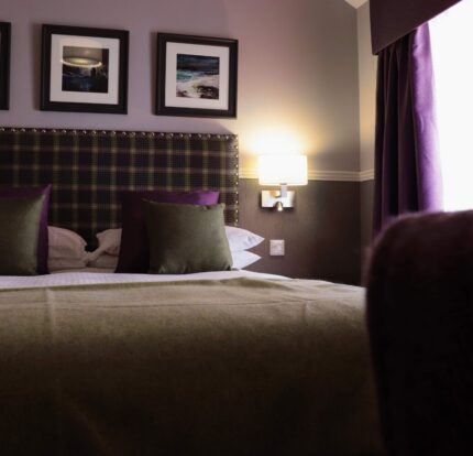 Cosy hotel room with a plush bed, elegant decor, and warm lighting, perfect for a relaxing stay.