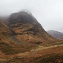 Scenic view of misty mountains and a lush valley, perfect for a tranquil retreat.