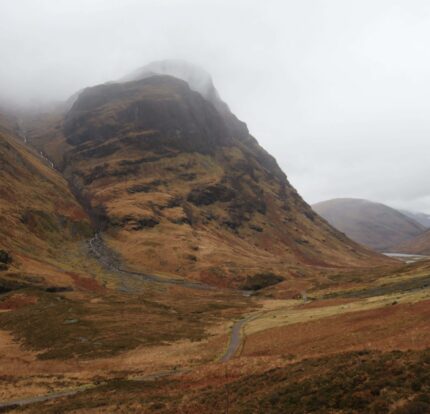 Scenic view of misty mountains and a lush valley, perfect for a tranquil retreat.