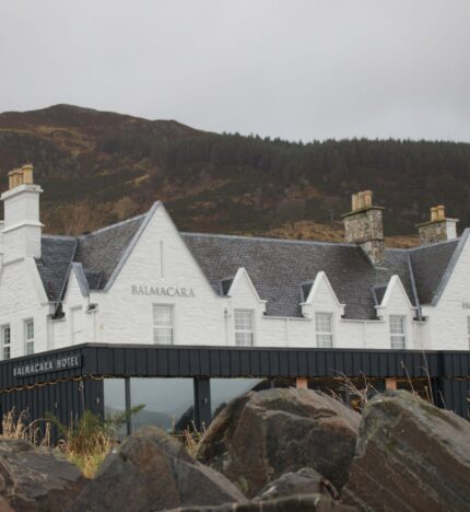 Historic Balmacara Hotel nestled against a scenic hillside, inviting guests for a cosy stay.