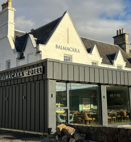 Charming Balmacara Hotel with inviting dining area, nestled in a serene countryside setting.